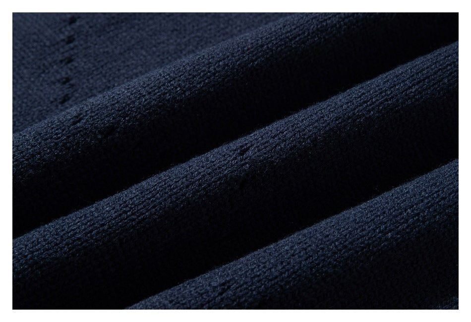 Macro view of dark navy knit sweater fabric draped in folds.