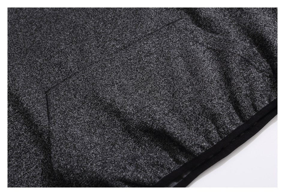 Close-up of a pocket and black-trimmed edge on dark heather-gray fabric.