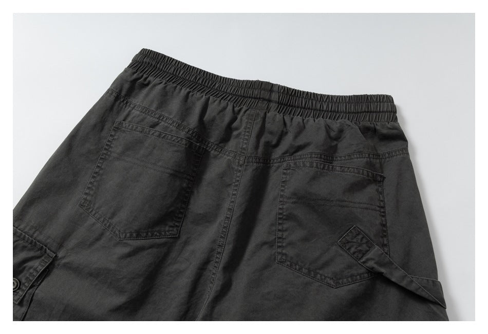 Partial rear view of charcoal pants showing an elastic waistband and two back pockets.