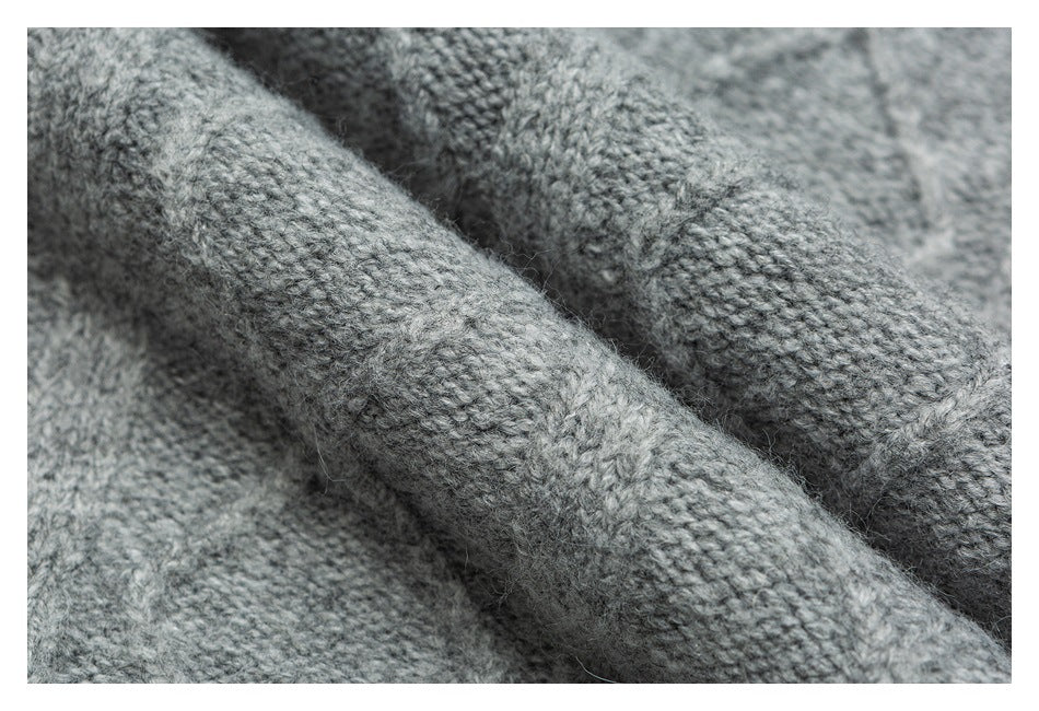 Extreme close-up of the gray sweater's textured knit stitches.