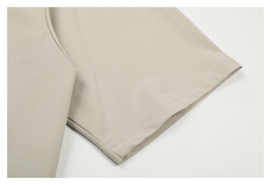 Close-up of a light beige garment sleeve with a double-stitched hem.