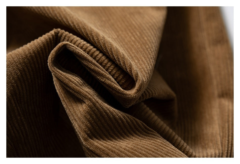 Macro view of brown corduroy pants folded to show the ribbed fabric and texture.