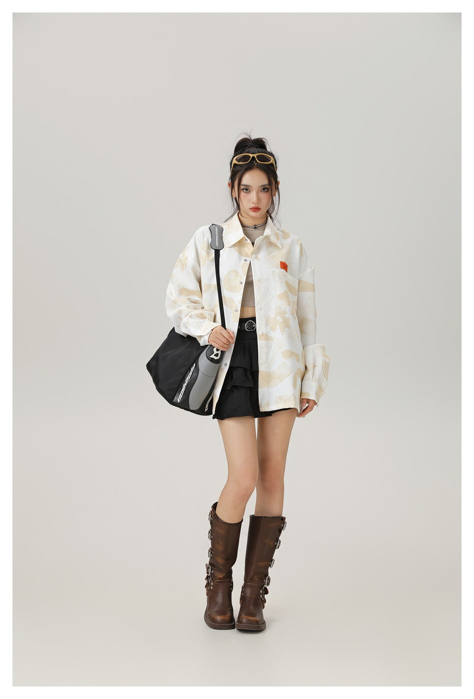 Model wearing an oversized cream button-up shirt with a beige abstract print, shown from the front.