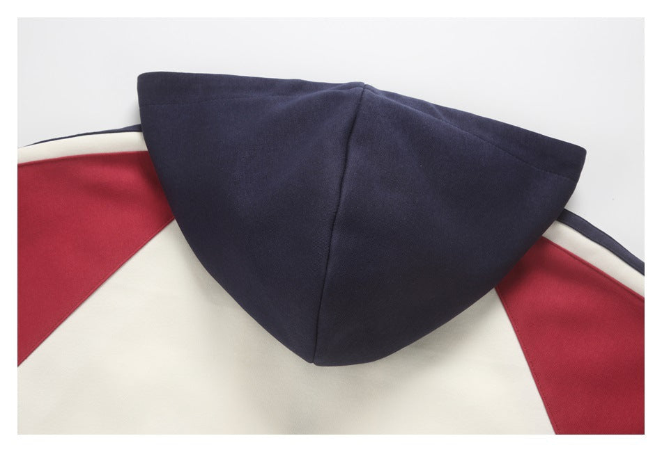 Close-up of a navy hood on a cream jacket with red and navy shoulder panels.