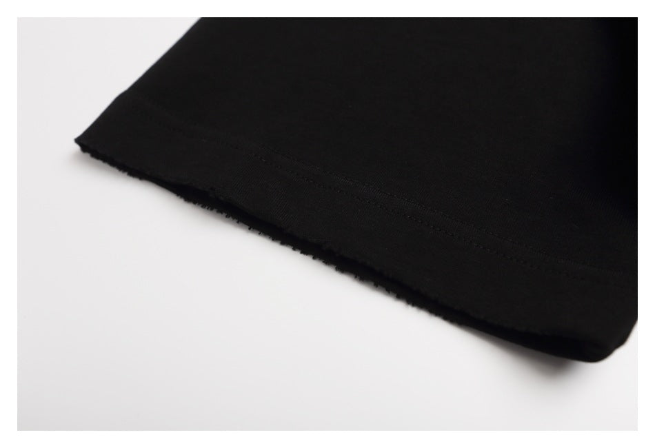 Close-up of the stitched hem on a black garment against a white background.