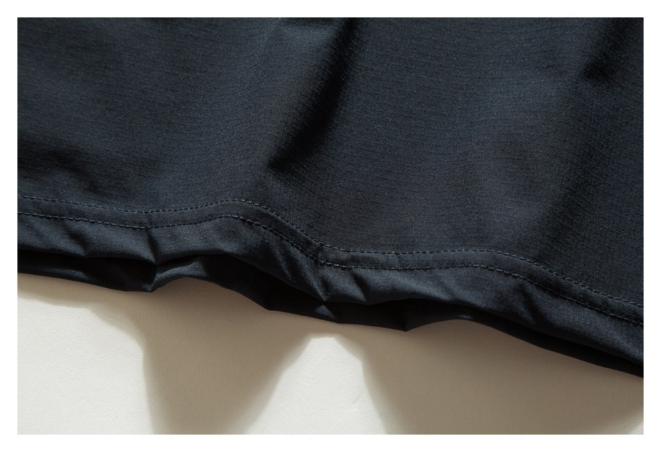 Close-up of the dark shirt's lower hem and stitching.