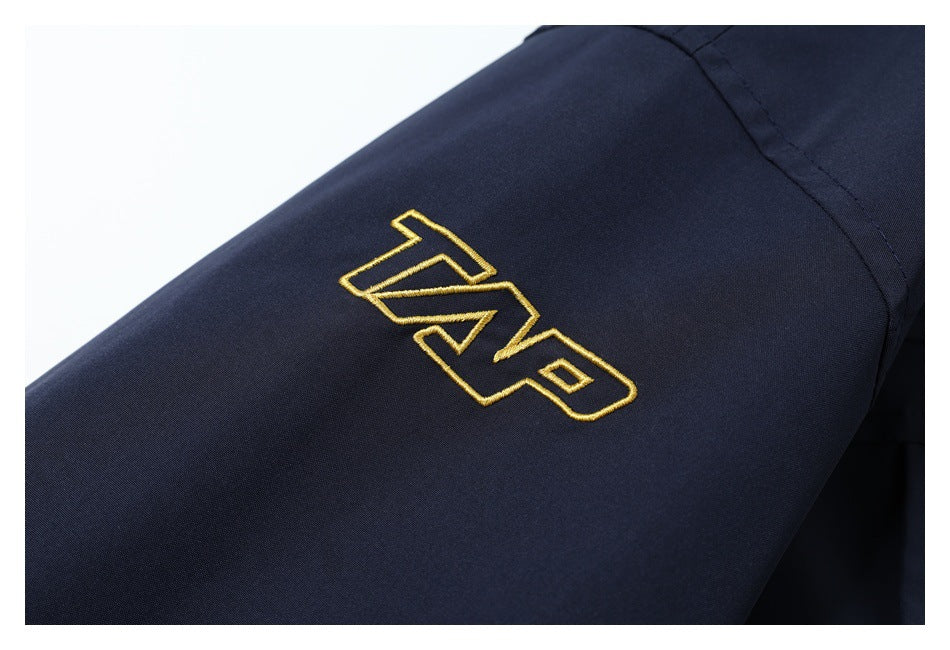 Close-up of a dark navy sleeve with gold embroidered lettering.