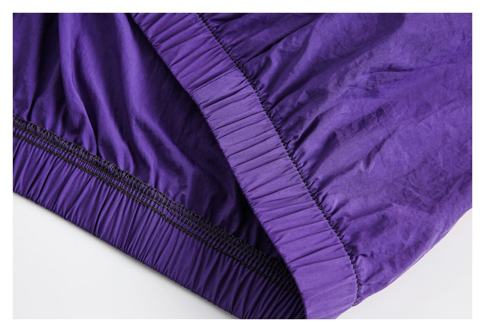 Close-up of a purple jacket hem with gathered elastic and reinforced stitching.