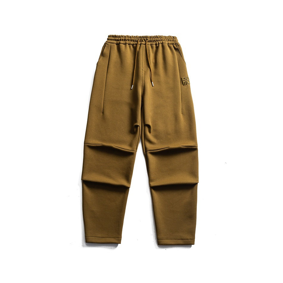 Green olive-brown knit drawstring sweatpants flat lay with knee pleats and a small logo on the thigh