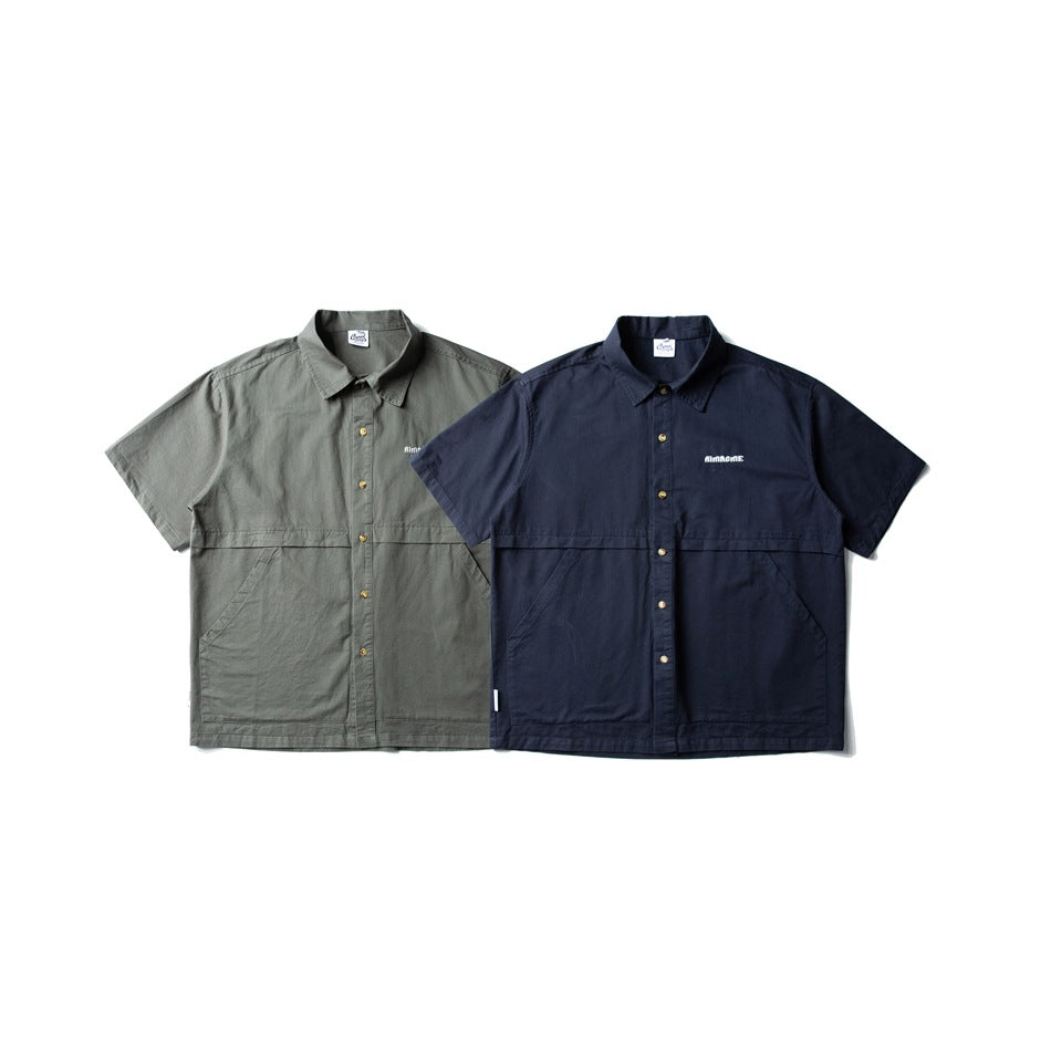 Front view of gray-green and navy short-sleeve button-up shirts with chest embroidery and large lower pockets.
