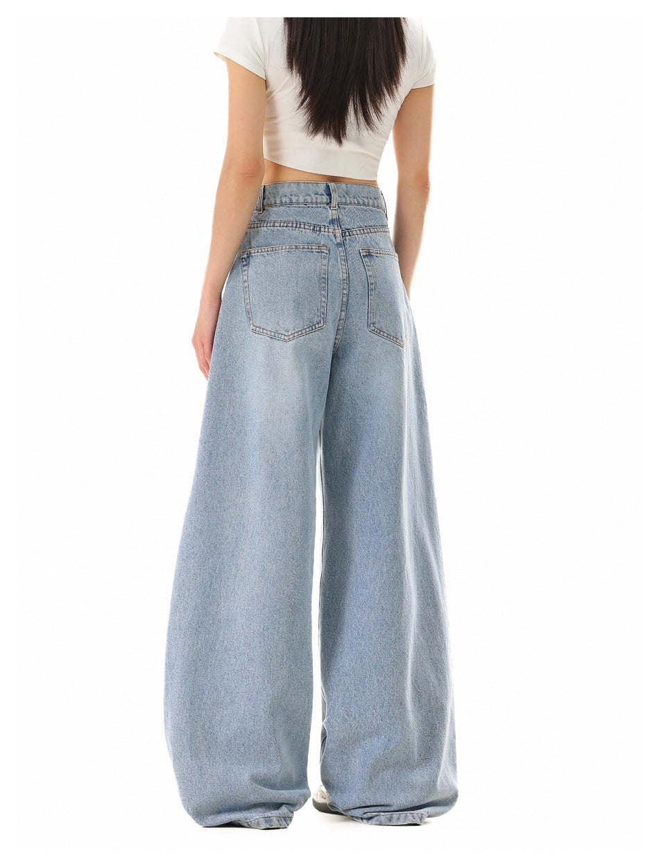 Back view of a model wearing light-wash, very wide-leg jeans with two back pockets and a white cropped T-shirt.