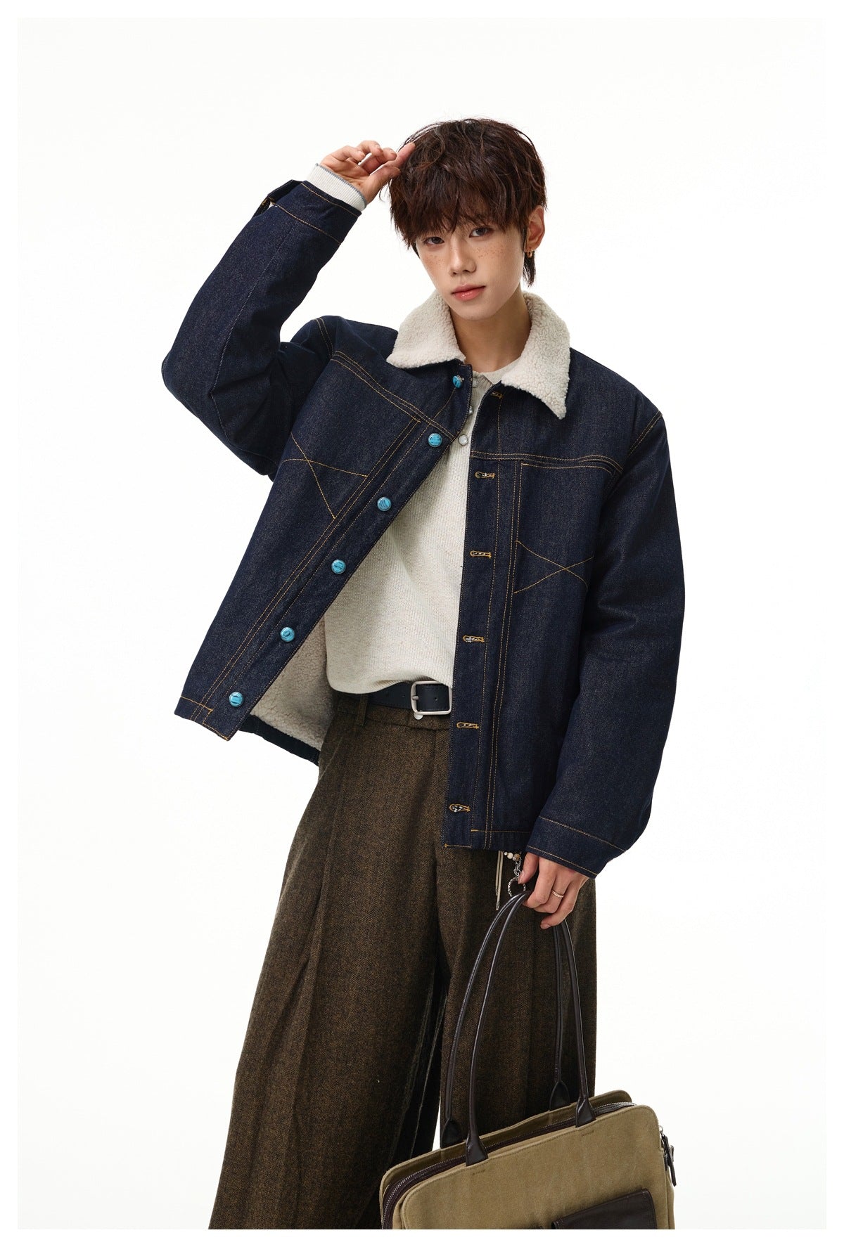 Model wearing an open dark indigo denim jacket with cream sherpa collar and lining, turquoise buttons, and contrast