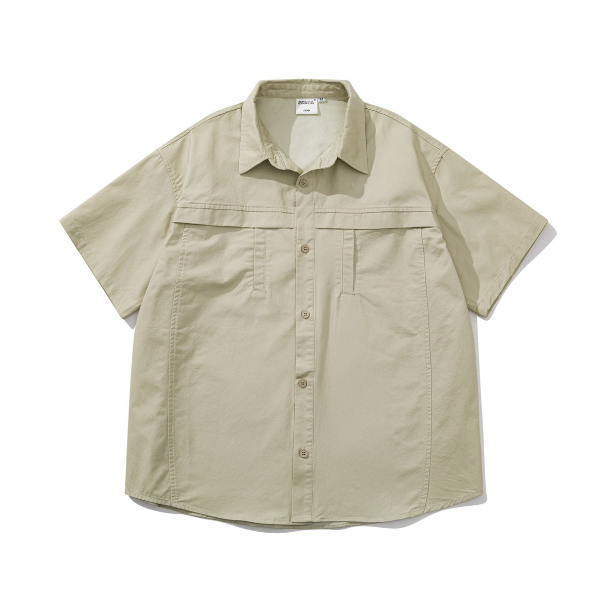 Khaki short-sleeve button-front shirt flat lay with chest yoke seam, two chest pocket openings and curved hem