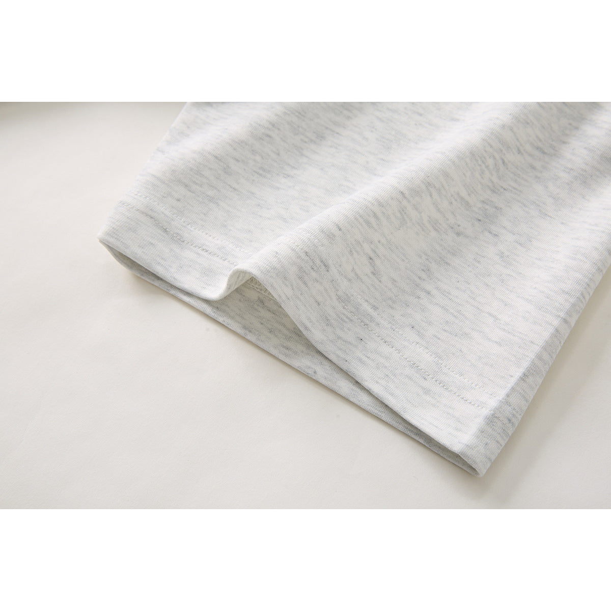 Close-up of the light gray heather polo shirt's short sleeve hem and stitching.