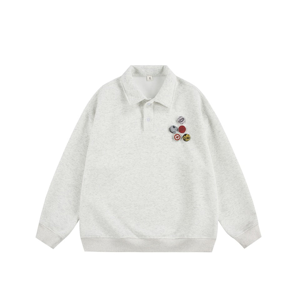 Light heathered gray polo-collar pullover with two buttons, ribbed cuffs and hem, and five round badges on the left chest