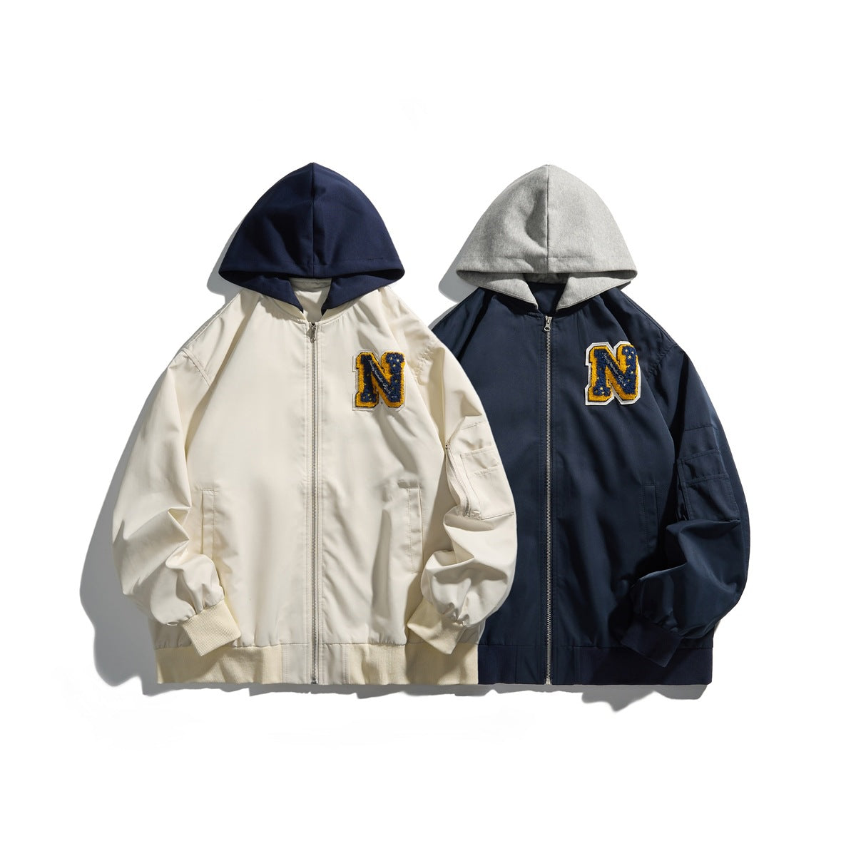 Two hooded zip-up jackets displayed side by side: ivory with a navy hood and navy with a gray hood.