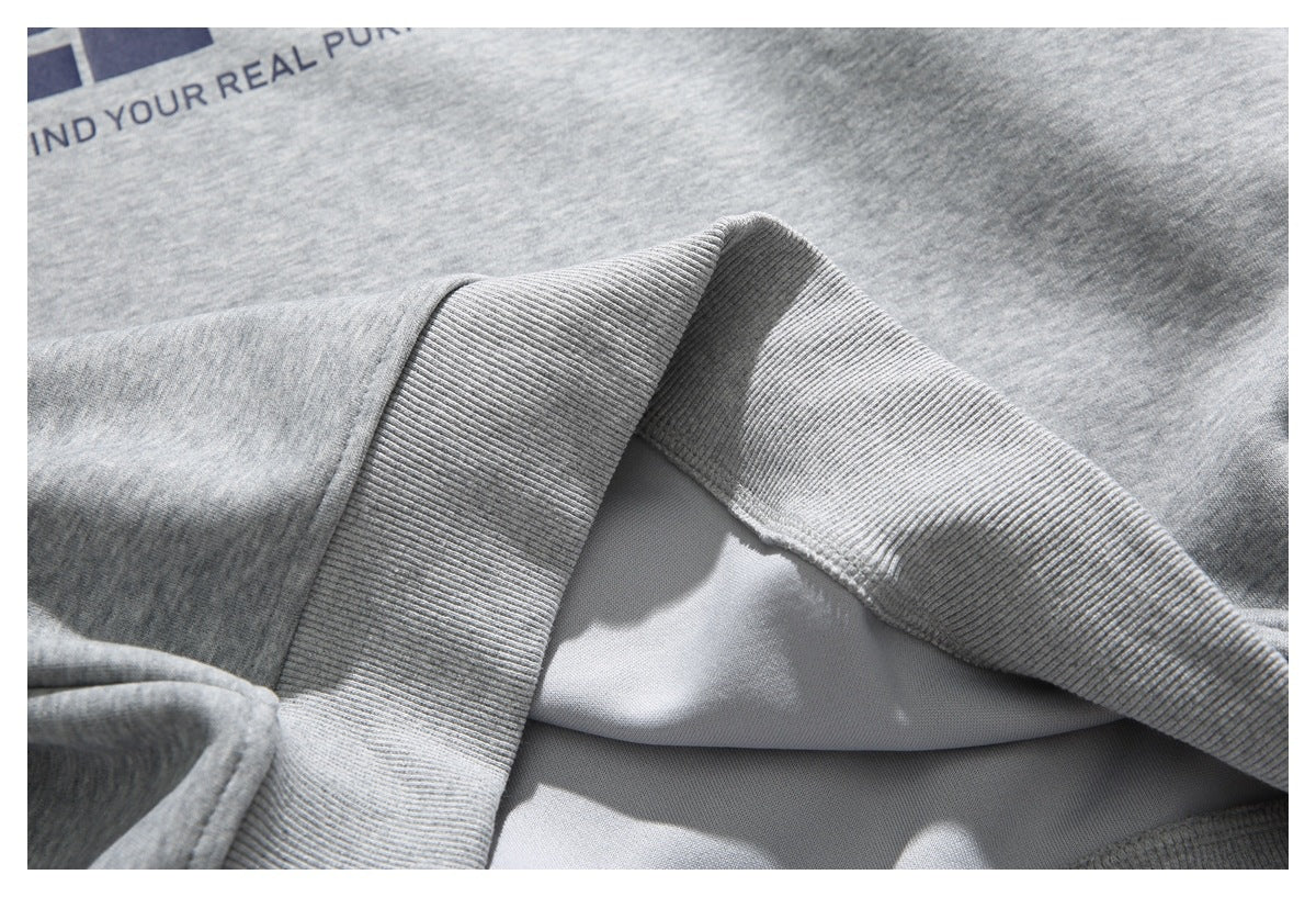 Close-up of a heather gray sweatshirt collar and inner seam, with part of a dark printed graphic visible.