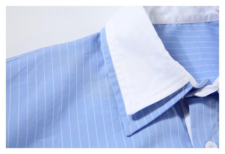 Close-up of the white collar and shoulder seam on a light blue pinstriped shirt.