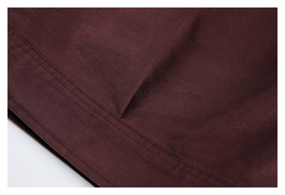 Close-up of burgundy fabric and a neatly stitched seam along a folded edge.