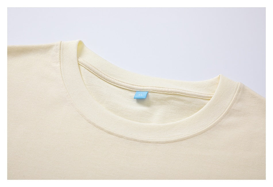 Cream T-shirt neckline with ribbed crew collar and blue XL label, shown close up.
