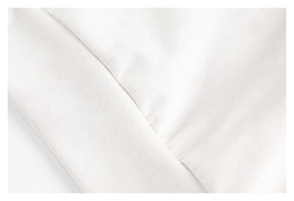 Close-up of a seam joining pale cream garment panels.