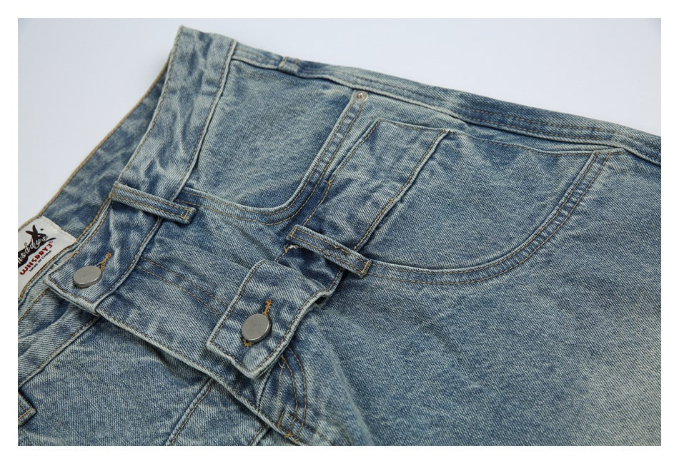 Close-up of light blue washed jeans showing the front waistband, metal buttons, belt loops and pockets.