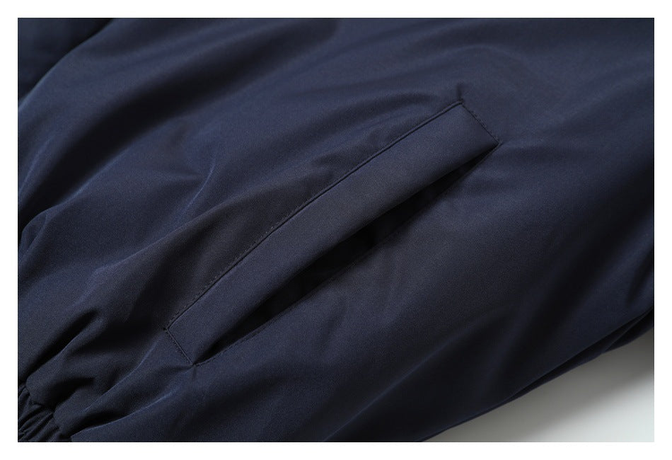 Close-up of a slanted welt pocket on dark navy fabric.