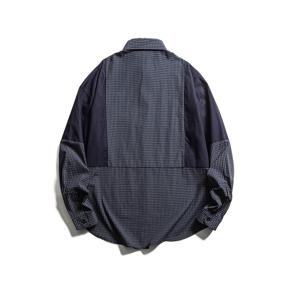 Back view of a navy shirt with a checked center and lower panel, solid sleeves, and checked cuffs.