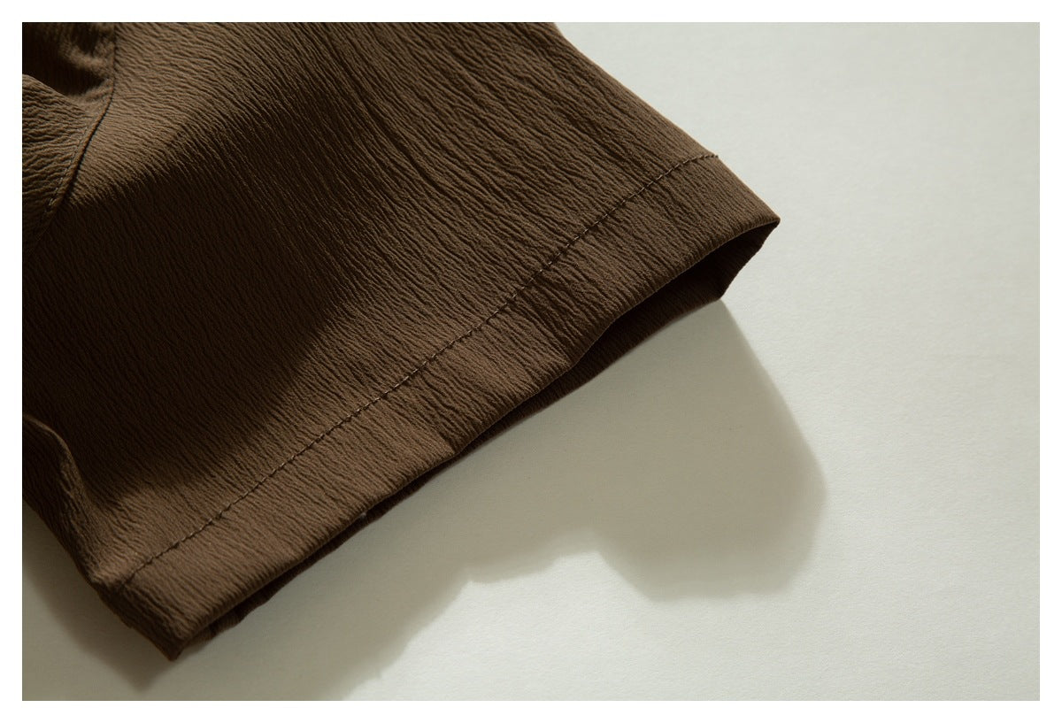 Close-up of a brown garment sleeve cuff with a stitched edge.