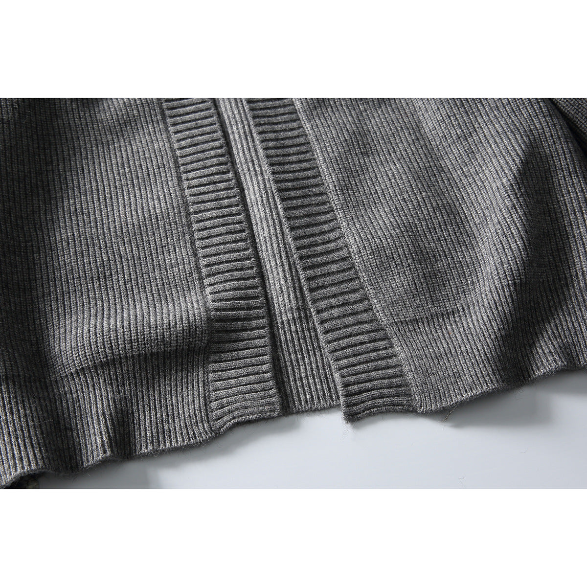 Close-up of the gray cardigan's ribbed front panels and lower edge.