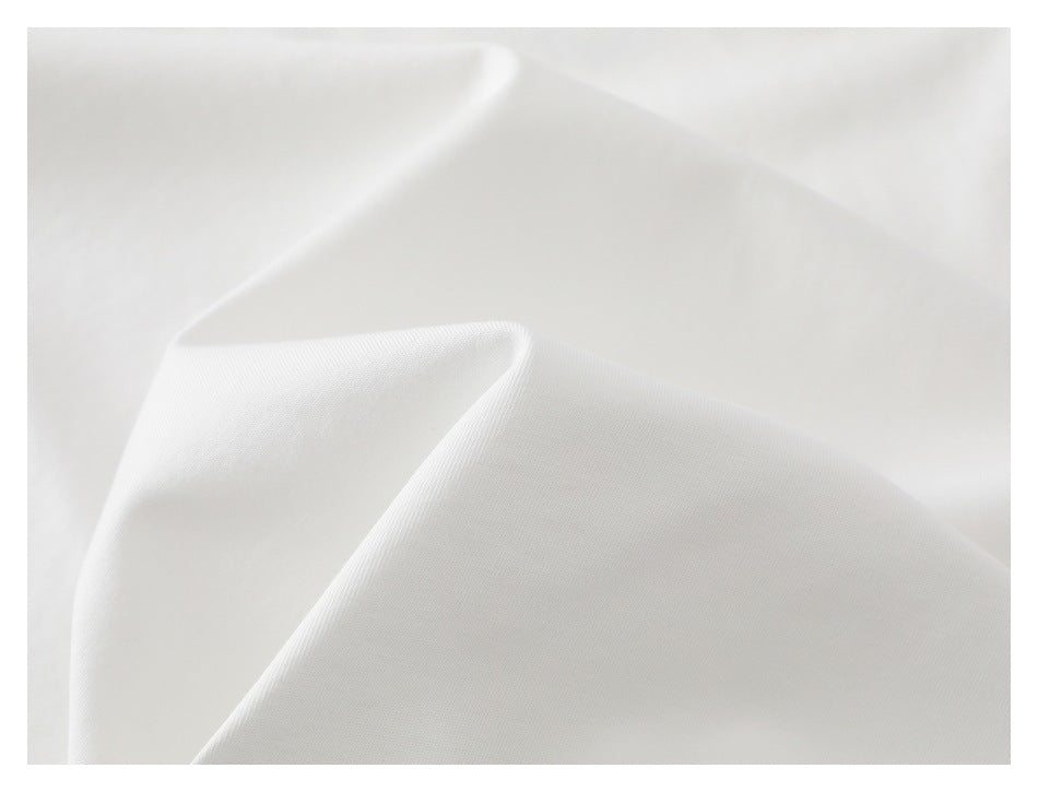 Close-up of white garment fabric draped into soft folds.