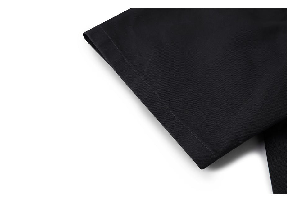 Close-up of a folded black garment edge with a stitched hem against a white background.