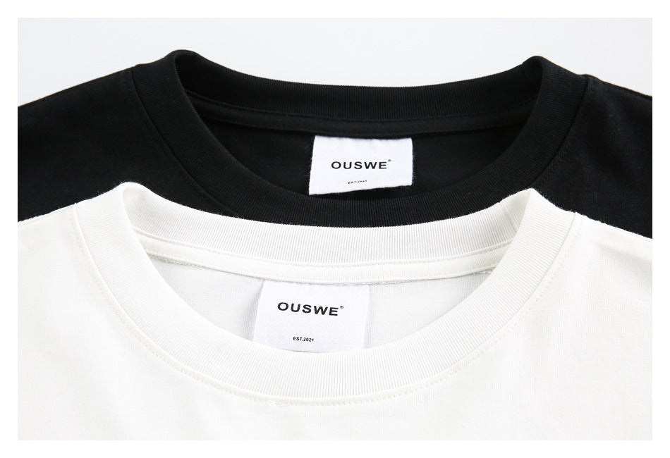 Close-up of black and white T-shirt necklines with visible OUSWE labels.