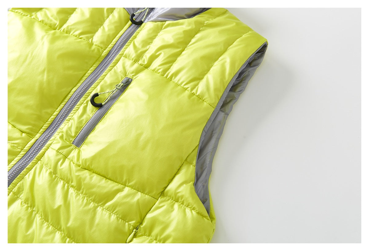 Angled close-up of a chartreuse quilted vest with gray zipper details and contrasting gray armhole lining.