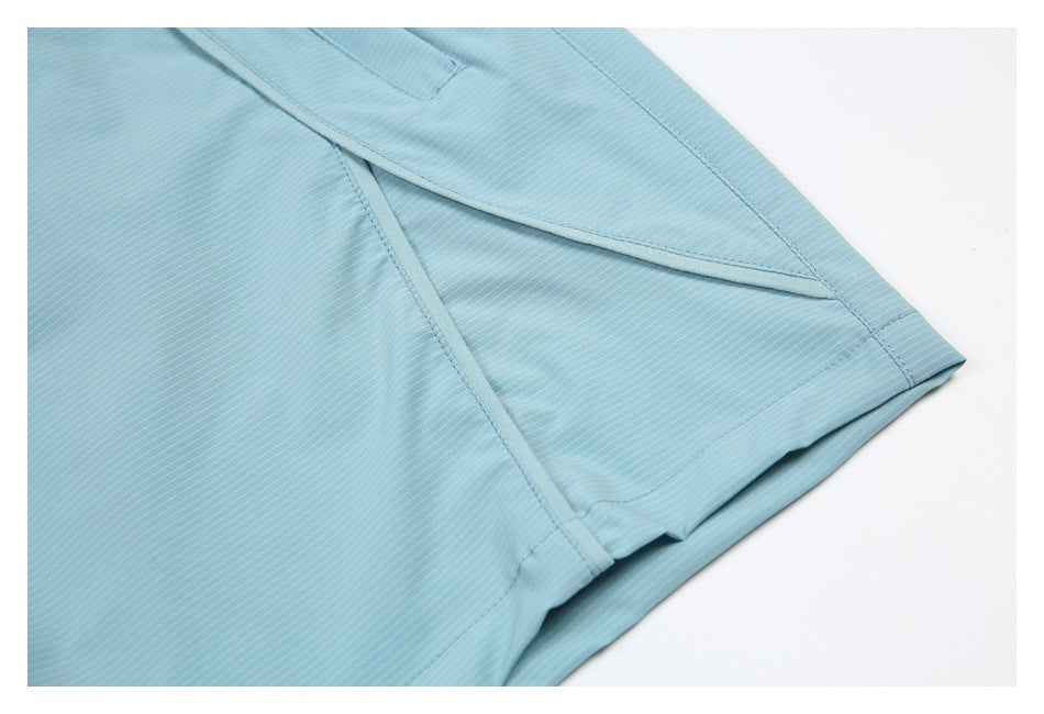 Close-up of the stitched hem and overlapping panels of light blue striped fabric.