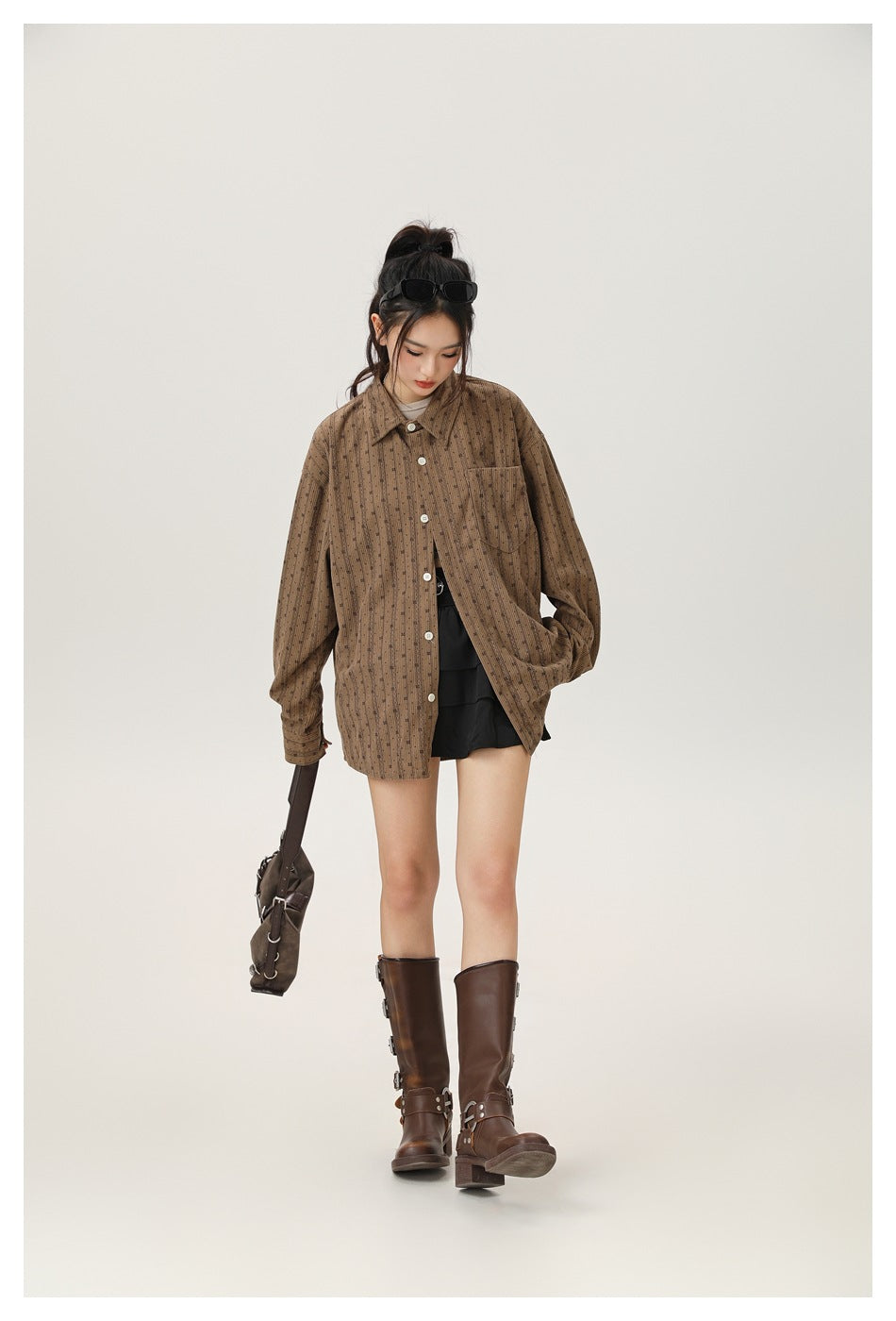 Model wearing the coffee brown striped oversized shirt buttoned with a black skirt and brown buckled boots