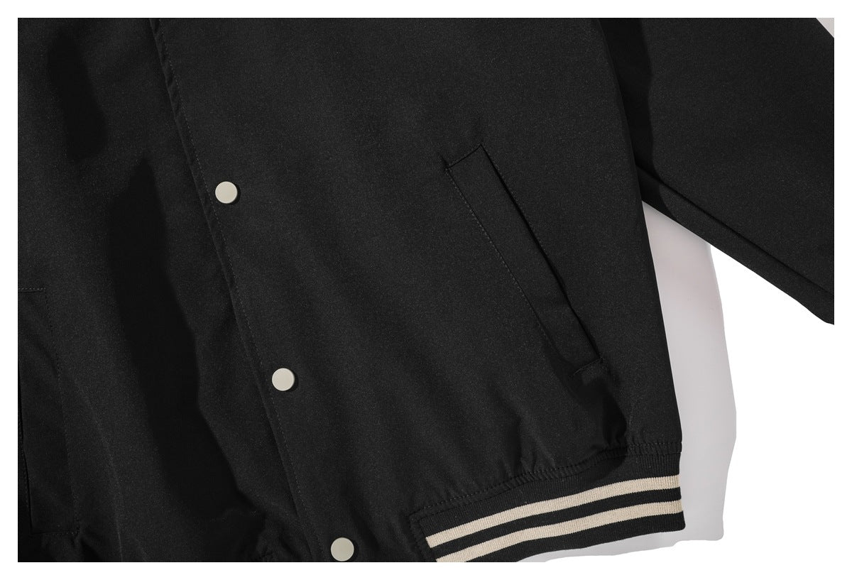Close-up of the black jacket's snap-front lower section, slanted pocket and striped ribbed hem.