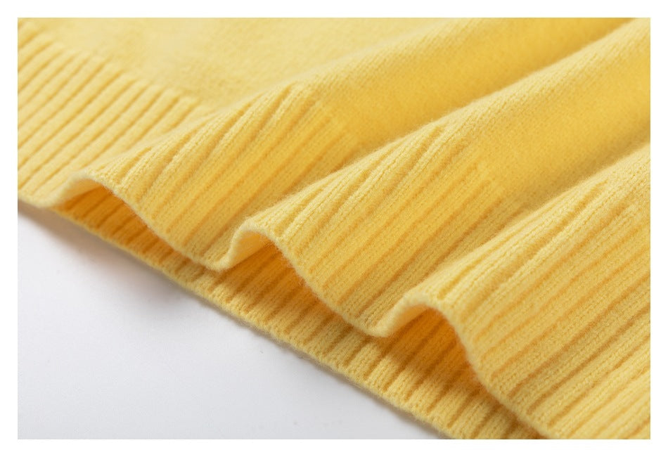 Close-up of the pale yellow sweater's ribbed hem and knit texture.