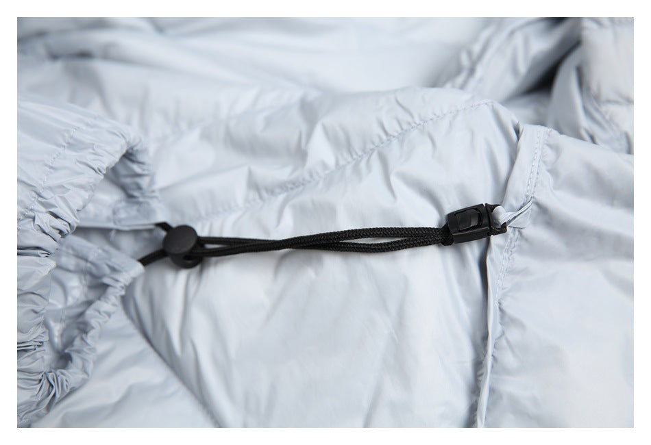 Close-up of a black drawcord and cord lock against the light gray jacket lining.