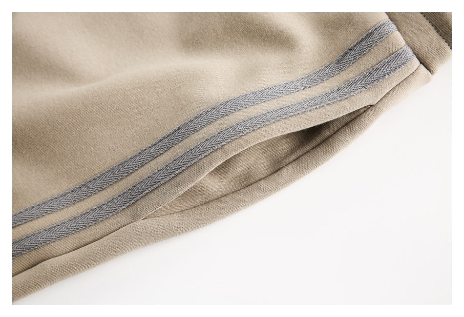 Close-up of a beige pant leg hem with two gray decorative bands.