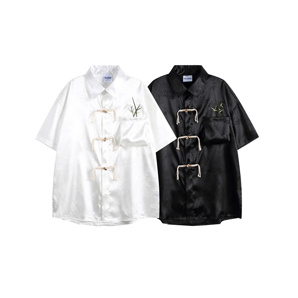 White and black short-sleeve knot-front shirts shown side by side, each with a chest pocket and bamboo embroidery.