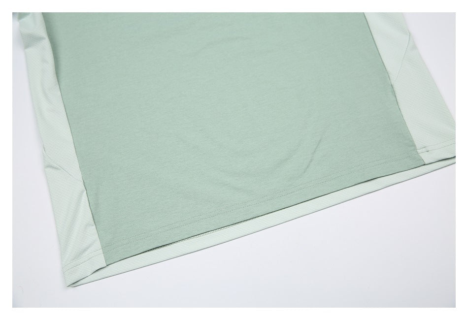 Close-up of the mint green shirt's lower body, hem, and pale contrasting side panels.