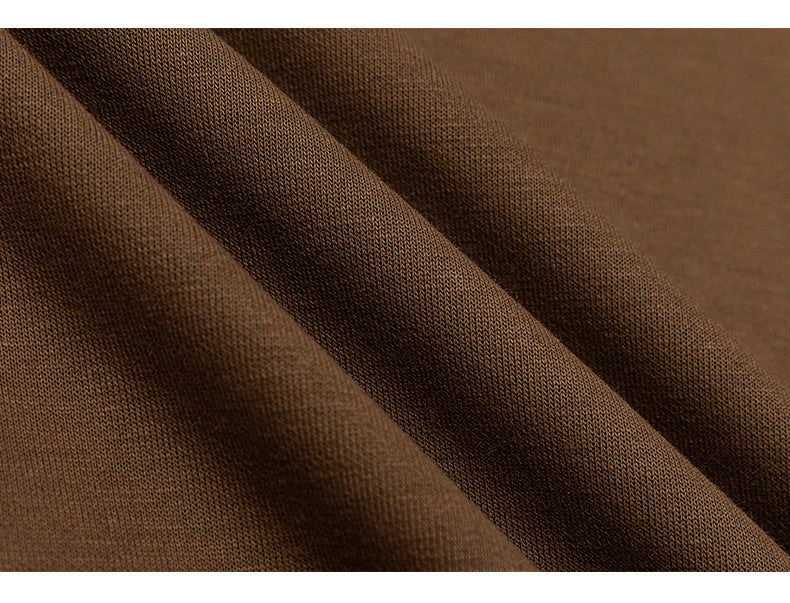 Macro view of the brown shirt fabric, showing its knit texture and folds.