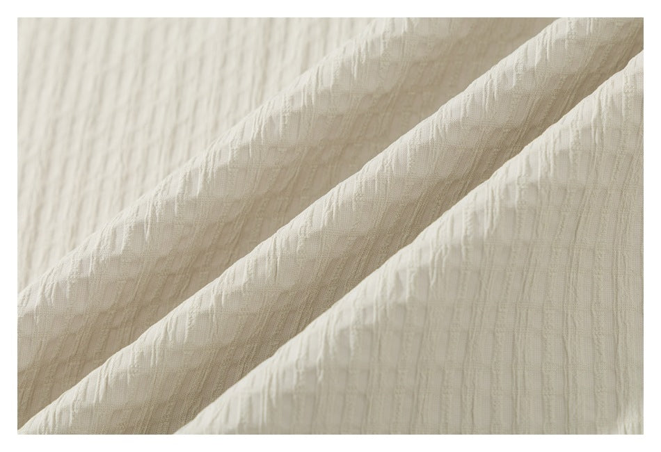 Close-up showing the raised, subtly patterned texture of cream shirt fabric.