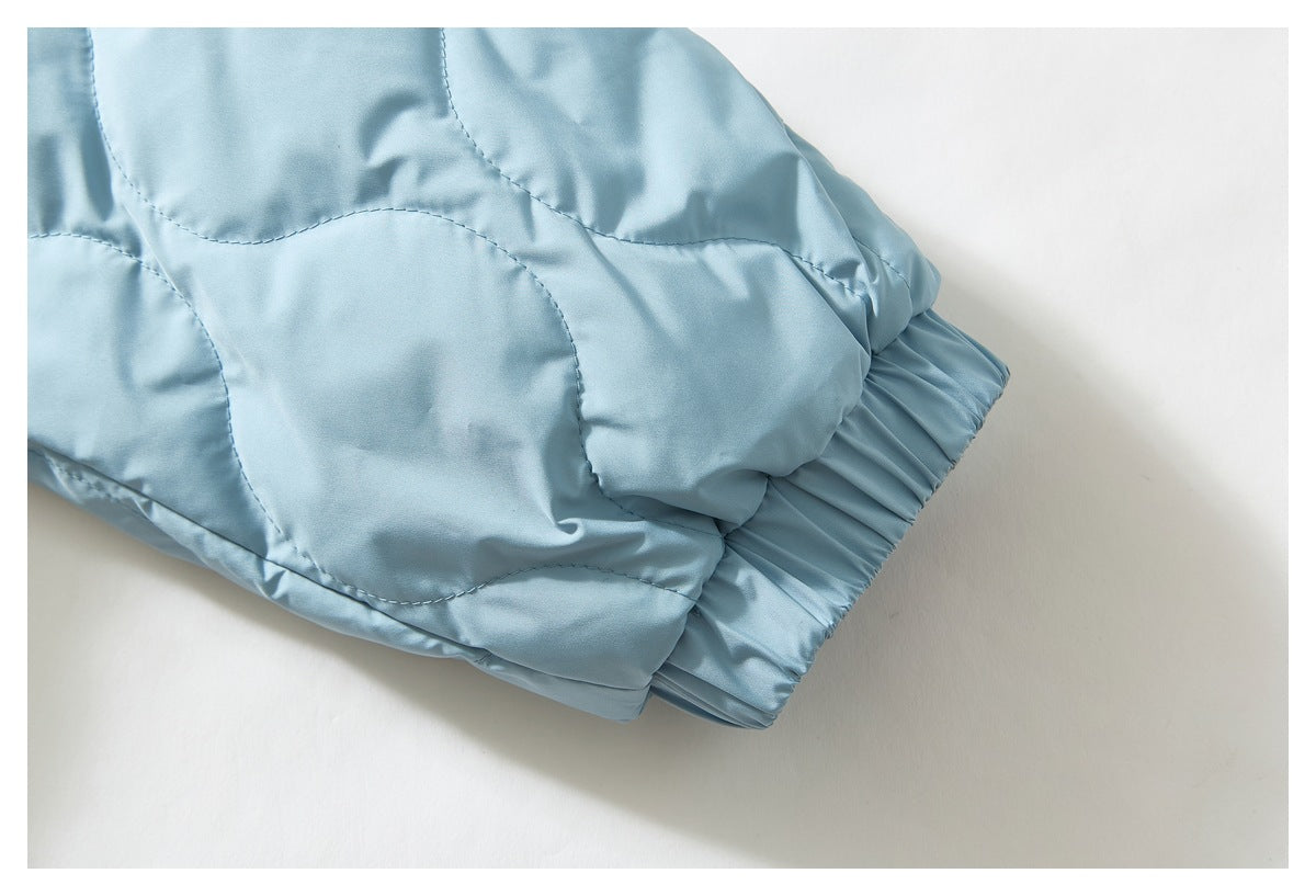 Close-up of the light blue jacket's quilted sleeve ending in an elasticated cuff.