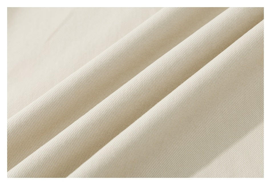 Close-up of cream-beige ribbed fabric arranged in soft diagonal folds.