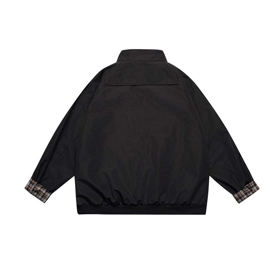 Back view of a black jacket with a stand collar, gathered hem, and beige plaid lining at the cuffs.