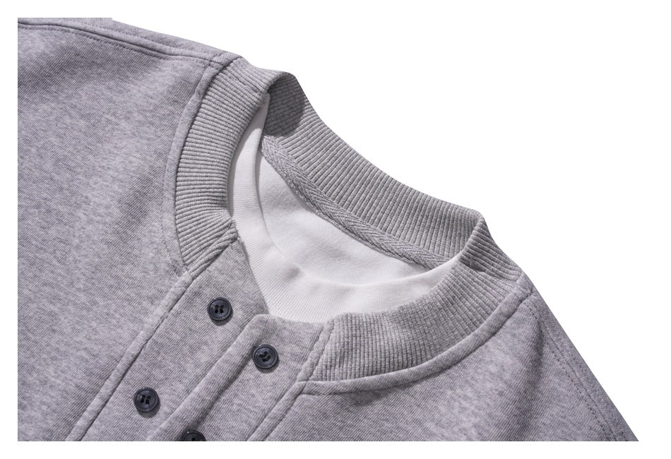 Close-up of a gray sweatshirt's ribbed collar and buttoned neckline.