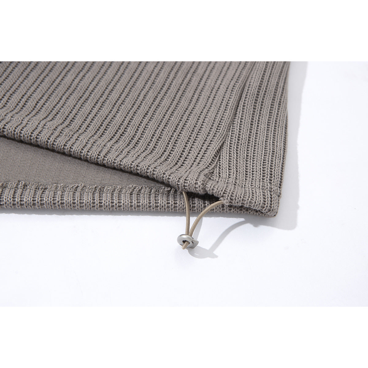 Close-up of the gray rib-knit shirt hem with an adjustable drawcord and toggle.