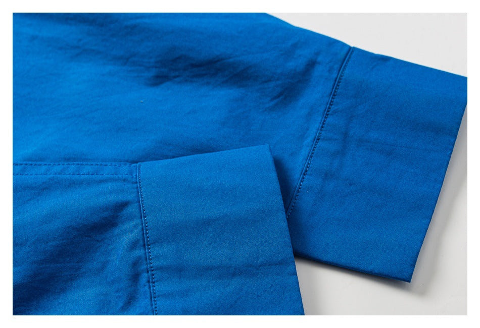Close-up of a bright blue garment showing a wide folded cuff and visible stitching.
